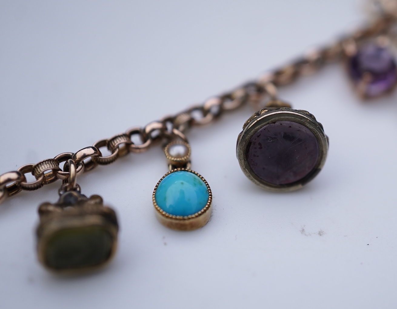 A gem-set charm bracelet, late 19th-early 20th century